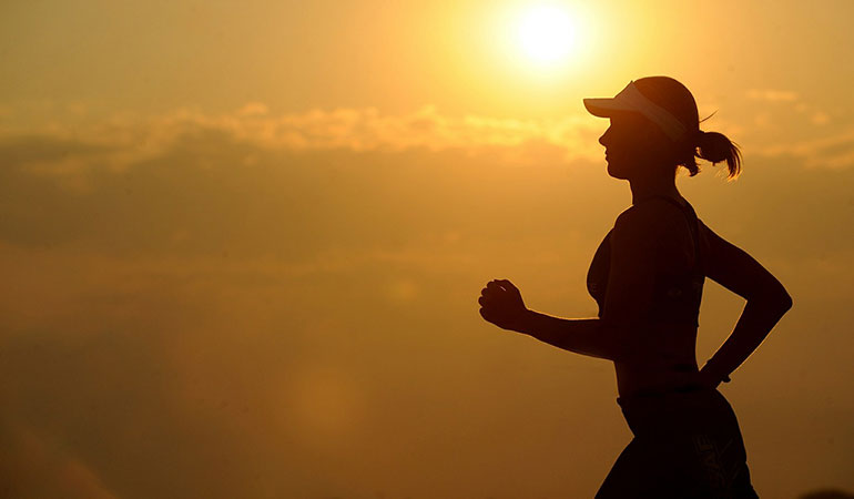 woman running infront of sunset